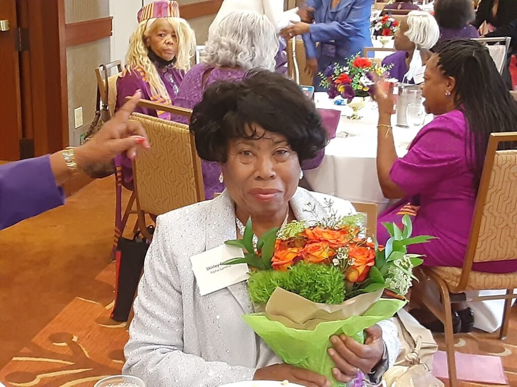 A woman holding flowers in her hands at an event.