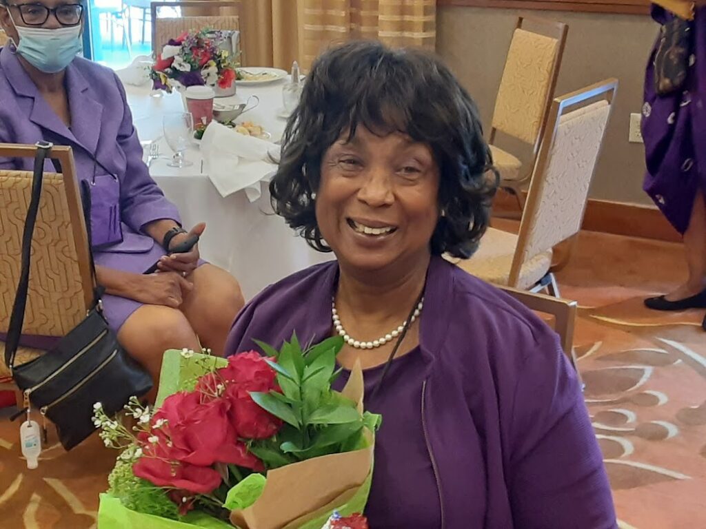 A woman holding flowers in a box at an event.