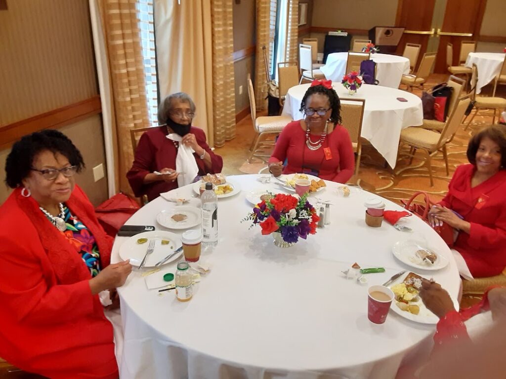 A group of women sitting at a table with plates.