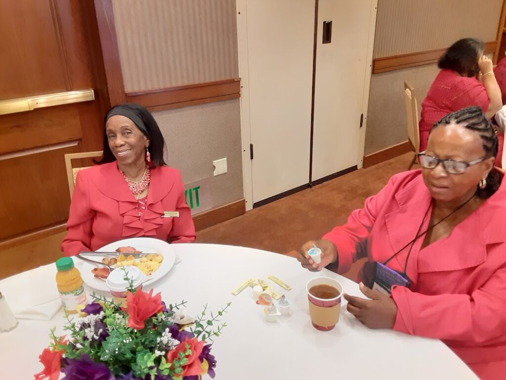 A group of women sitting at a table with food.