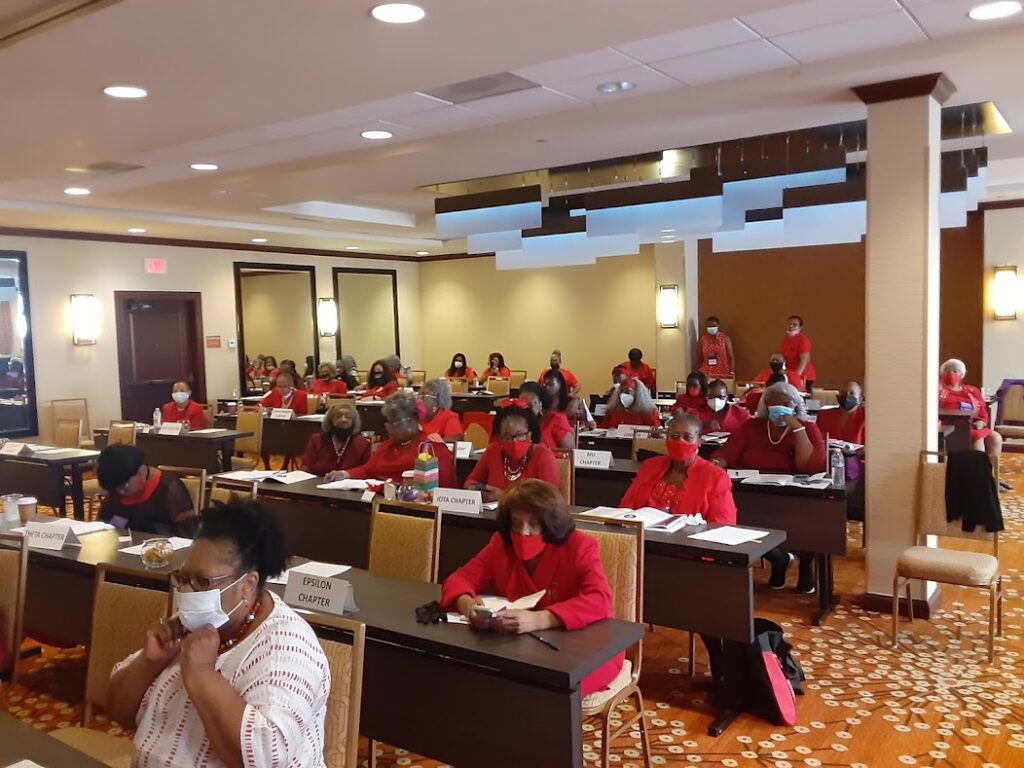 A group of people sitting at tables in front of laptops.