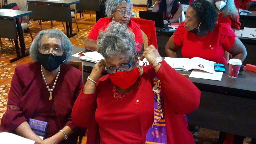 A group of women wearing red and masks.