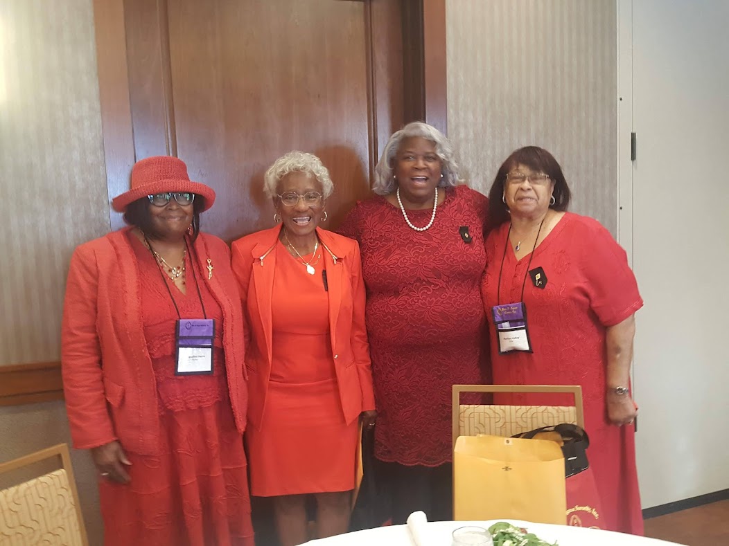 Four women in red outfits posing for a picture.