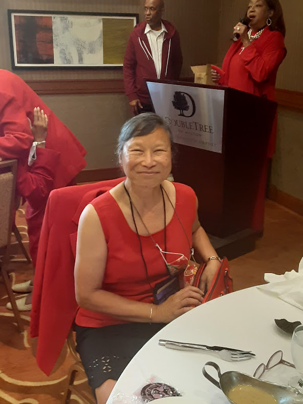 A woman in red is sitting at the table