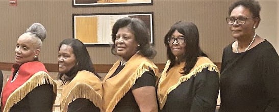 Two women in black and yellow outfits standing next to each other.