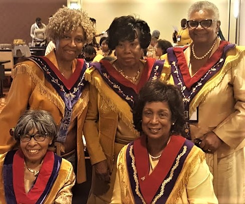 A group of women in yellow and red outfits.