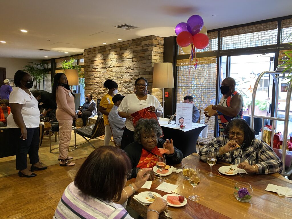 A group of people sitting at tables eating food.