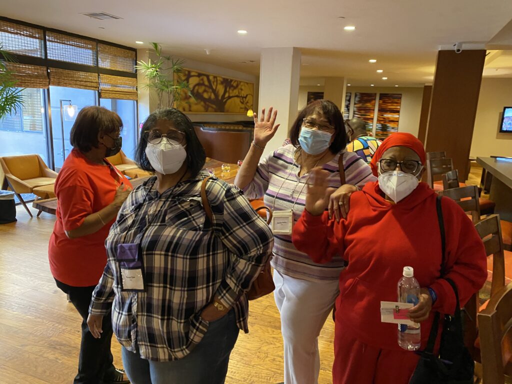 A group of women wearing masks and standing in a room.