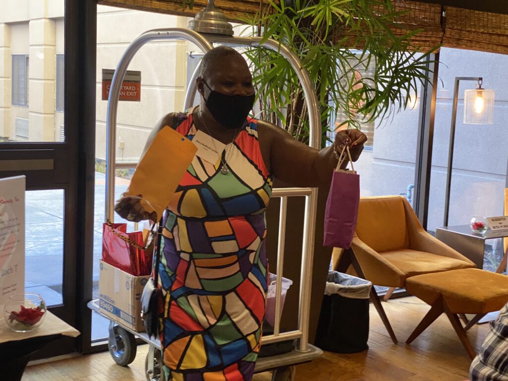 A woman in colorful dress holding onto some bags