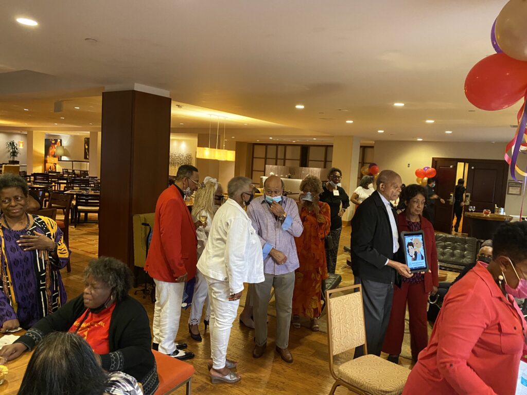 A group of people standing around in a room.