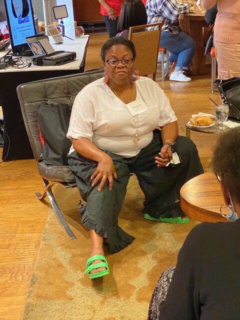 A woman sitting on the floor with her feet up.