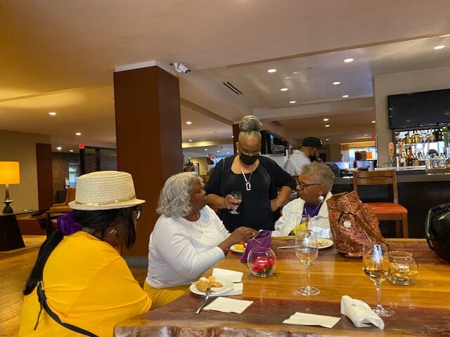 A group of people sitting at a table with food.