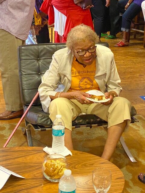 A woman sitting on the floor eating food.