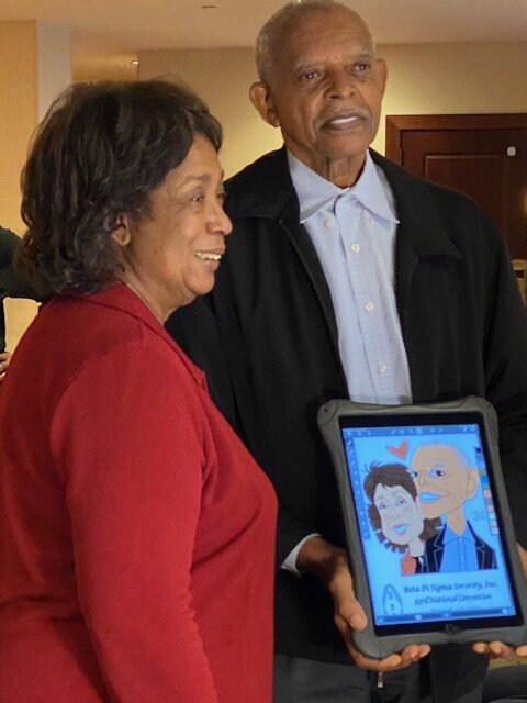 A man and woman holding an ipad with cartoon pictures on it.