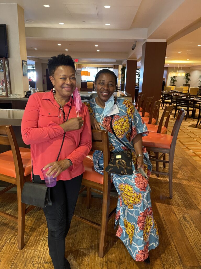 Two women standing next to each other in a restaurant.