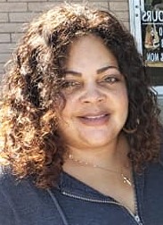 A woman with curly hair and a smile.